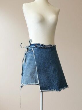 Reconstructed denim skirt with asymmetrical front overlay and raw frayed hem